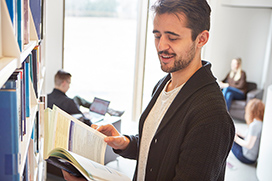 Student reading book at the stacks