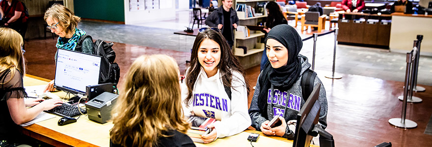 Students picking up materials at the Weldon Library Service Desk