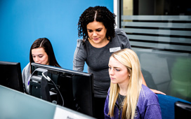 Staff member helping a student on a computer