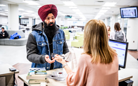 Student checking out items at the service desk