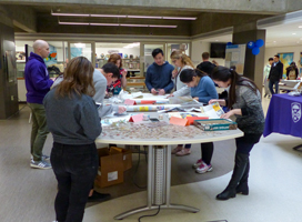 Students browsing through old maps at the craft table