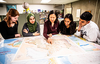 Staff assisting students with maps
