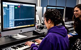 Student using a computer with a musical keyboard